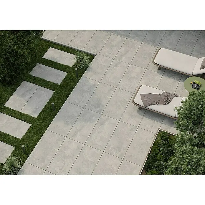 Queens Terrassenfliese - 59,3 x 119,3 x 2 cm, Grau, Matt - Luftaufnahme einer Terrasse mit grauen Fliesen, Sonnenliegen und Grünflächen. Die Fliesen dominieren das Bild.