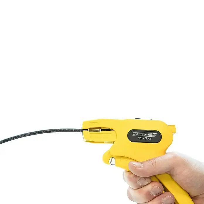 Weicon Kabelentmanteler Abisolierzange No. 7 Solar - 1,5 mm² - 10 mm², Gelb - Nahaufnahme eines gelben Weicon Tools No. 7 Solar Abisolierwerkzeugs, das ein schwarzes Kabel hält, das von einer Hand gehalten wird.