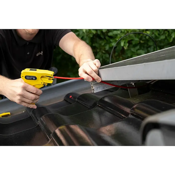 Weicon Kabelentmanteler Abisolierzange No. 7 Solar - 1,5 mm² - 10 mm², Gelb - Elektriker, der mit einem gelben Abisolierwerkzeug an der Installation von Solarmodulen auf einem Dach arbeitet.