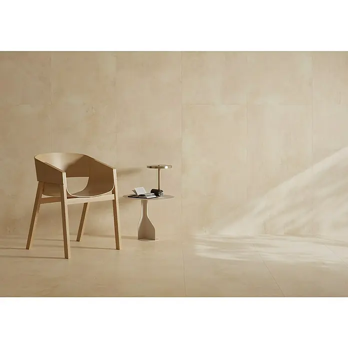 Queens Feinsteinzeugfliese - 29,8 x 59,8 cm, Beige, Matt - Eine minimalistische Szene mit einem Holzstuhl, einem Beistelltisch mit Lampe und Buch, vor einem beigen Wand- und Bodenhintergrund.