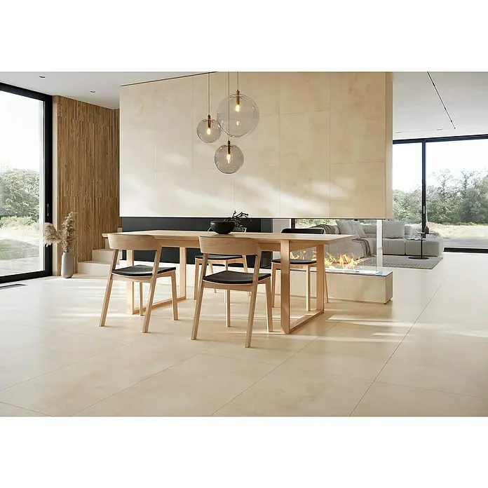 Queens Feinsteinzeugfliese - 29,8 x 59,8 cm, Beige, Matt - Helles Esszimmer mit Holztisch und Stühlen unter modernen Hängelampen, daneben ein Kamin. Elegantes Wohndesign mit natürlichem Licht.