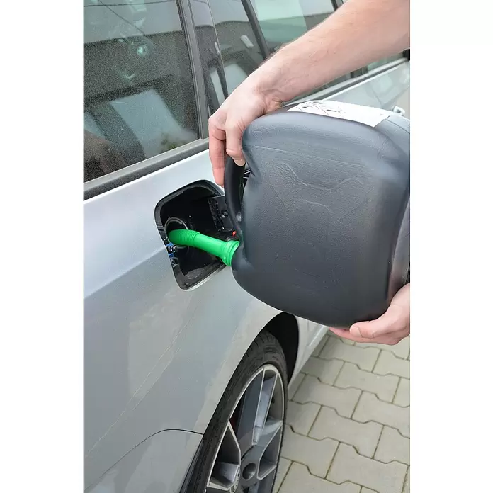 Cartrend Benzinkanister - 5 l, Polyethylen - Eine Person füllt mit einem schwarzen Kanister und grünem Ausgießer Kraftstoff in ein silbernes Auto.