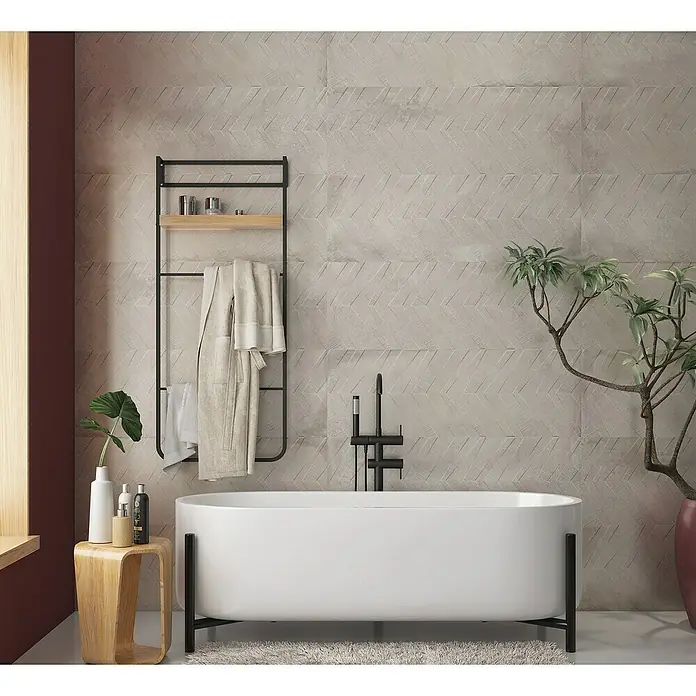 Revestimiento de pared Origin Arrow - 30 x 90 cm, Arena, Mate, Rectificado - Arreglo de bañera con toallero, taburete y planta. El diseño moderno, con una bañera blanca y elementos decorativos, crea un ambiente relajante.