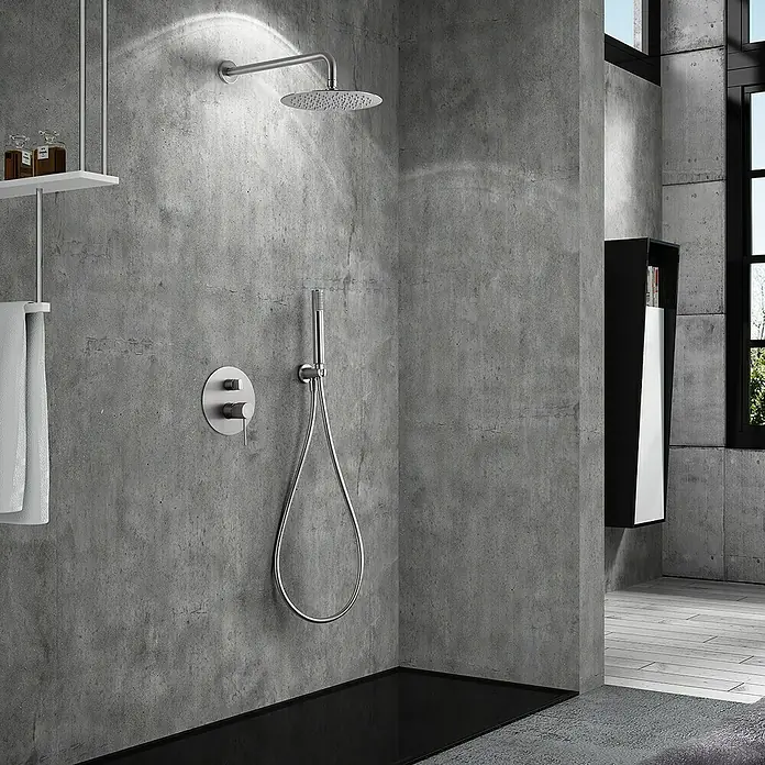 Imex Line Sistema de ducha empotrado - Níquel - Grifería de ducha de diseño moderno con rociador de lluvia y ducha de mano sobre pared de hormigón gris.