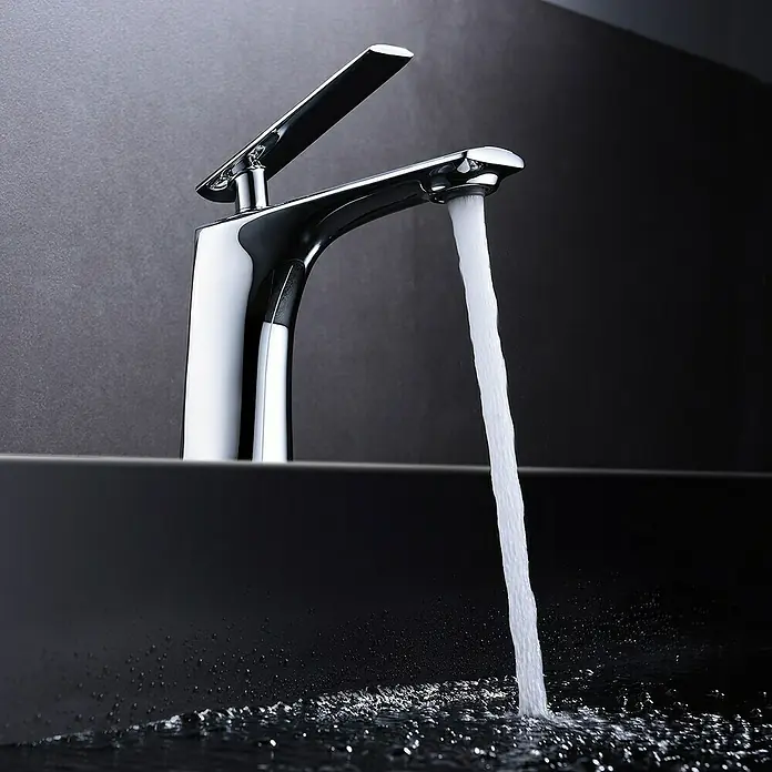 Imex Escocia Grifo de lavabo - Cromo, Brillante - Primer plano de un moderno grifo cromado con agua que fluye hacia un lavabo oscuro sobre un fondo gris.