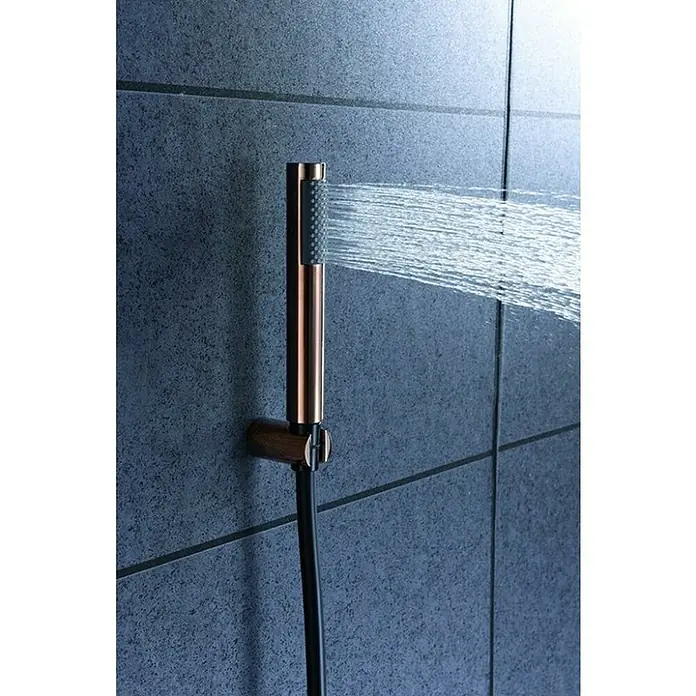 Imex Olimpo Sistema de ducha empotrado - Con grifo monomando, Negro/Oro rosa - Primer plano de una grifería de ducha con agua rociando, sobre un fondo de pared alicatada. El diseño es moderno y elegante.