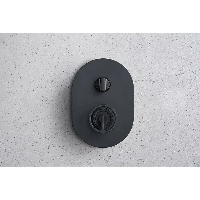 Imex Olimpo Sistema de ducha empotrado - Con grifo monomando, Negro - Primer plano de un grifo de ducha negro mate con un diseño redondo sobre una pared moteada.