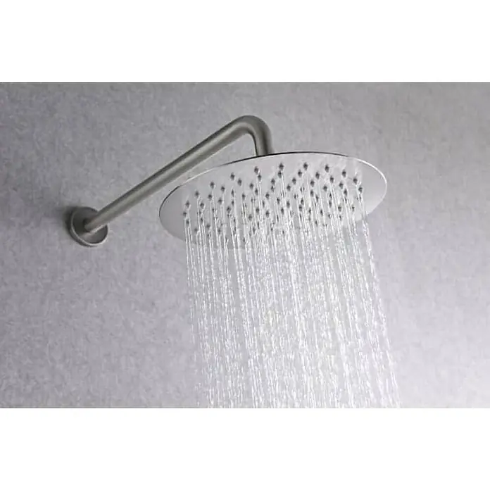 Imex Line Sistema de ducha empotrado - Níquel - Primer plano de un cabezal de ducha redondo de acero inoxidable que emite chorros de agua, montado en una pared gris.