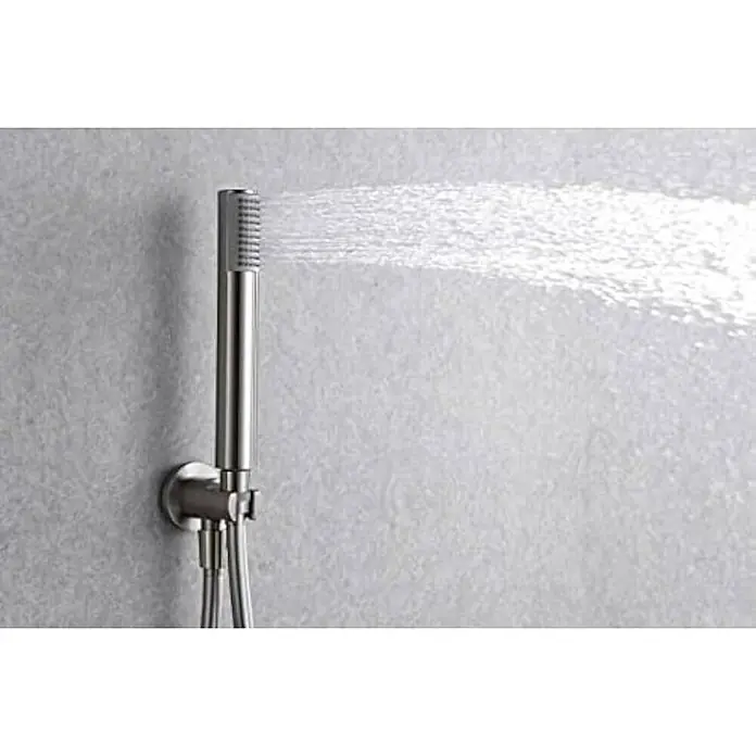 Imex Line Sistema de ducha empotrado - Níquel - Primer plano de una ducha de mano en funcionamiento, rociando agua contra una pared texturizada.