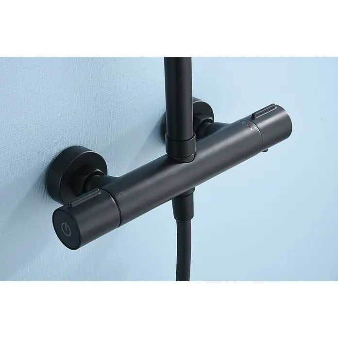 Imex Sistema de ducha Kent - Con grifo termostático, Negro - Primer plano de un moderno termostato de ducha negro montado en una pared azul, que muestra un diseño de baño elegante y minimalista.