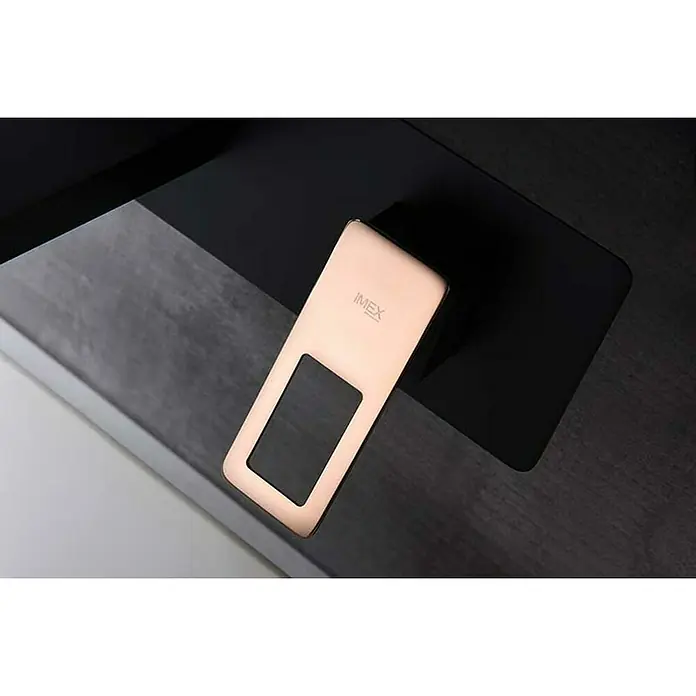 Imex Suecia Grifo de lavabo empotrado - Negro/Oro rosa - Primer plano de un producto IMEX con diseño elegante, colocado sobre una superficie de tonos múltiples. Enfatizando formas elegantes y materiales de calidad.