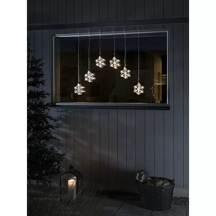 Konstsmide LED-Lichtervorhang Schneeflocken - Länge: 90 cm, Lichtfarbe: Warmweiß, Anzahl Leuchtmittel: 48 Stk., Netzbetrieben, IP44 - Beleuchtete Schneeflocken-Fensterlichter hängen nachts in einem Hausfenster und schaffen eine festliche Winterdekoration.