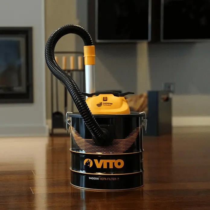 Vito Aspirador de cenizas eléctrico VIASC18T - 1.400 W, Volumen de recipiente: 18 l, Sin bolsa - Primer plano de una aspiradora con filtro HEPA VITO 1400W negra y amarilla exhibida sobre un piso de madera brillante.