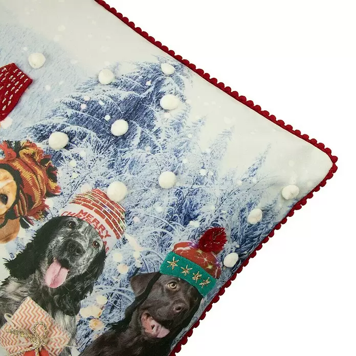 Kissen Hunde - Weihnachten, 50 x 30 cm, 100 % Polyester - Weihnachtskissen mit Hunden in Mützen, schneebedecktem Waldhintergrund, weißen Pompons und rotem Wellenrand.