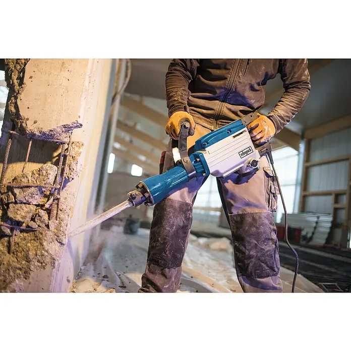 Scheppach Abbruchhammer AB 1600 - 1.600 W, 50 J, SDS-Hex-Aufnahme - Nahaufnahme eines Abbruchhammers von Scheppach im Einsatz, der Beton und Stahl zerbricht, während ein Arbeiter ihn bedient.