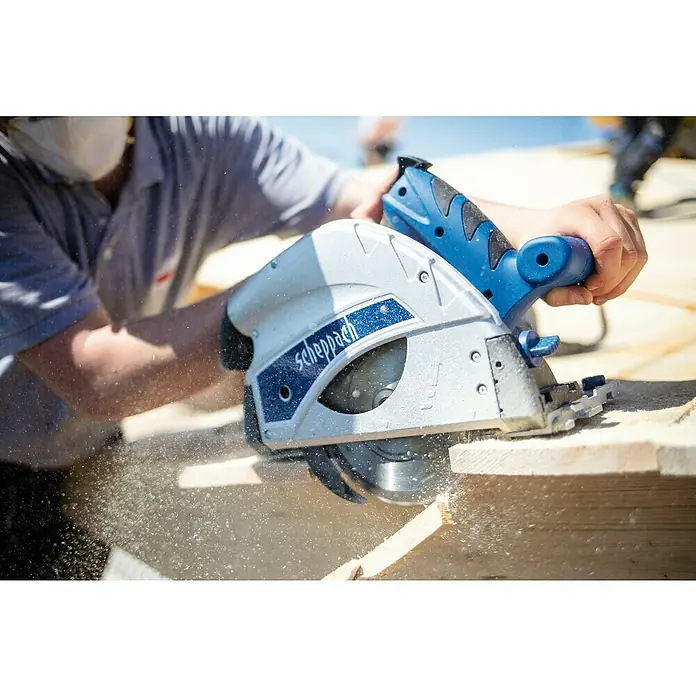 Scheppach Tauchsäge PL 55 Special Edition - 1.200 W - Eine Nahaufnahme einer Scheppach Handkreissäge in Aktion, die Holz schneidet, wobei Sägemehl herumfliegt und die Präzision des Werkzeugs betont wird.