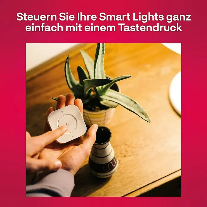 Innr Lighting Dimm- & Schaltcontroller Remote kabellose Steuerung - Weiß - Eine Hand drückt den Einschaltknopf einer weißen, quadratischen Smart-Licht-Fernbedienung zur Steuerung von Lichtern im Haus.