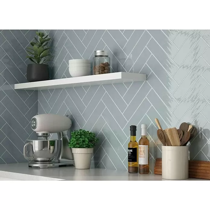 BHS Showroom Revestimiento de pared Travel - 7,5 x 30 cm, Aquamarina, Brillante - Azulejos azul claro en espiga formando un salpicadero de cocina, algunos con una sutil textura cepillada.