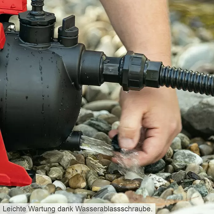 Scheppach Gartenpumpe GP600S - 600 W, Max. Fördermenge: 3.000 l/h - Schwarze Wasserpumpe mit roten Akzenten wird entleert, indem eine Person die Wasserablassschraube öffnet, was einfache Wartung zeigt.