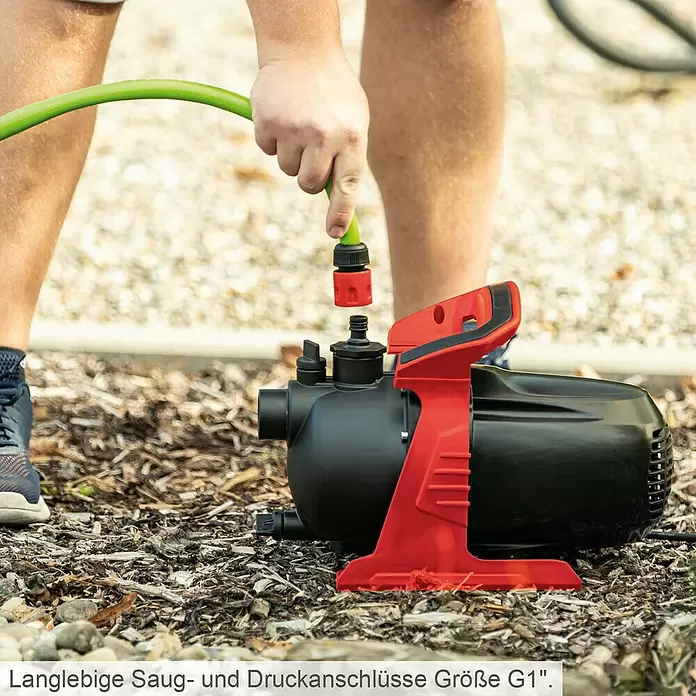 Scheppach Gartenpumpe GP600S - 600 W, Max. Fördermenge: 3.000 l/h - Person verbindet grünen Schlauch mit schwarzer und roter Wasserpumpe im Freien.