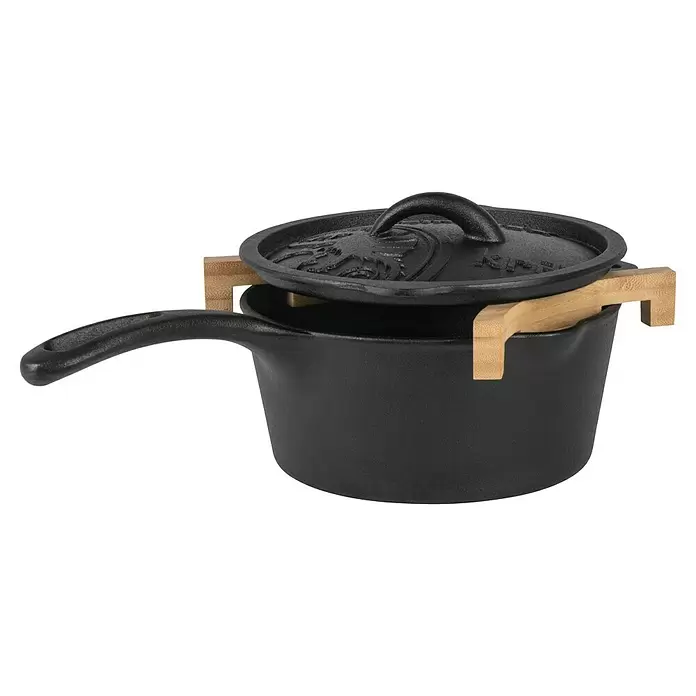 Petromax Abstandhalter für Feuertöpfe - Holz, 2 Stk. - Schwarzer gusseiserner Topf mit Deckel, leicht geöffnet auf hellem Holzständer.