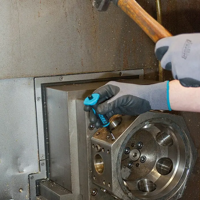 Hazet Splinttreiber-Set 751HS/5 - 5 -tlg., 3 mm - 8 mm - Ein Arbeiter benutzt einen HAZET-Splintentreiber mit einem Hammer, um an einer Metallstruktur zu arbeiten.