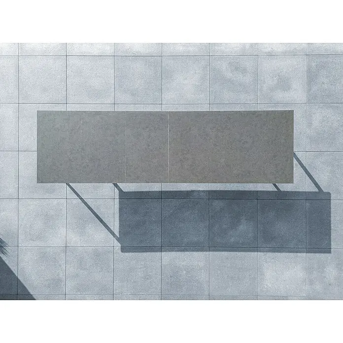 Sunfun Solo Gartentisch - L x B x H: 230 x 100 x 76,5 cm, Aluminium, Sintered Stone, Night-Grey, Ausziehbar - Draufsicht auf einen grauen Tisch, der auf einem gefliesten Untergrund steht und einen Schatten wirft. Perfekt für den Außenbereich.