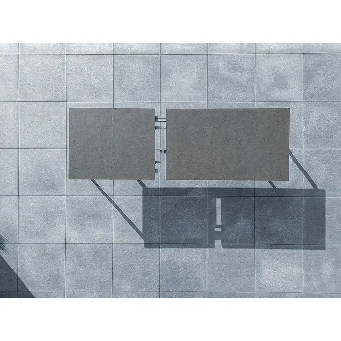 Sunfun Solo Gartentisch - L x B x H: 230 x 100 x 76,5 cm, Aluminium, Sintered Stone, Night-Grey, Ausziehbar - Draufsicht auf zwei graue Outdoor-Tische auf einer gefliesten Terrasse, die sich perfekt für entspannte Stunden im Freien eignen.