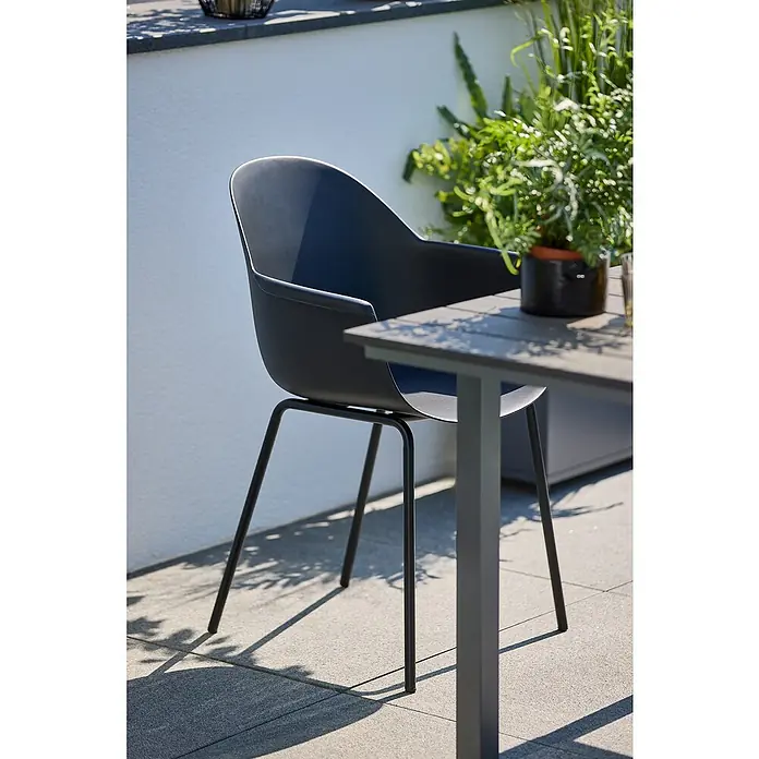 Sunfun Balkonmöbel-Set Maja/My - 5 -tlg., Night-Grey/Schwarz - Ein moderner, grauer Stuhl aus Kunststoff mit Metallbeinen steht neben einem passenden Tisch auf einer Terrasse.