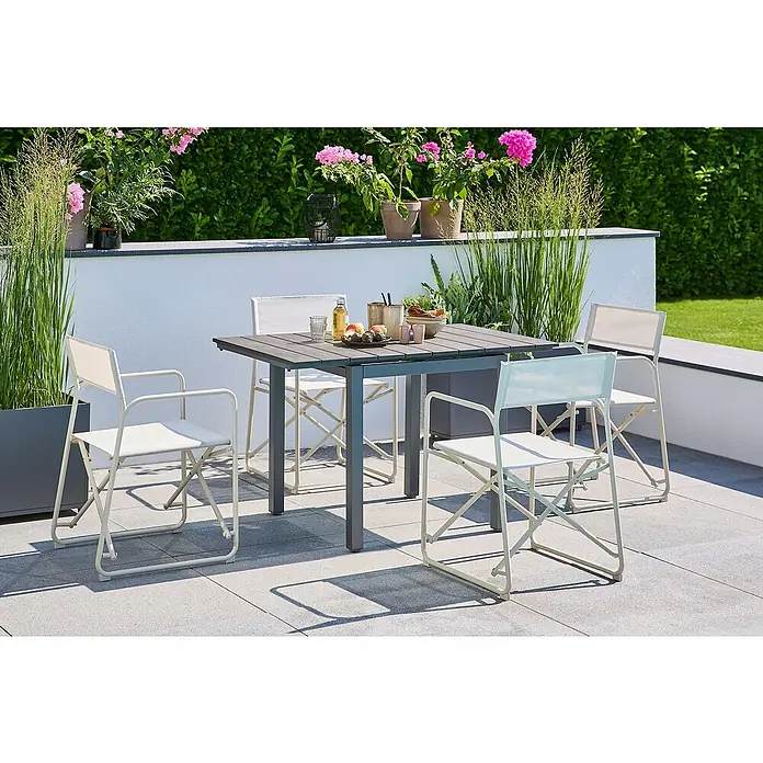 Sunfun Balkonmöbel-Set Maja/Sarah - 5 -tlg., Night-Grey/Light-Greige - Ein quadratischer Gartentisch mit vier passenden Klappstühlen, ideal für Mahlzeiten im Freien. Die Sitzgruppe steht auf einer Terrasse mit Pflanzen im Hintergrund.
