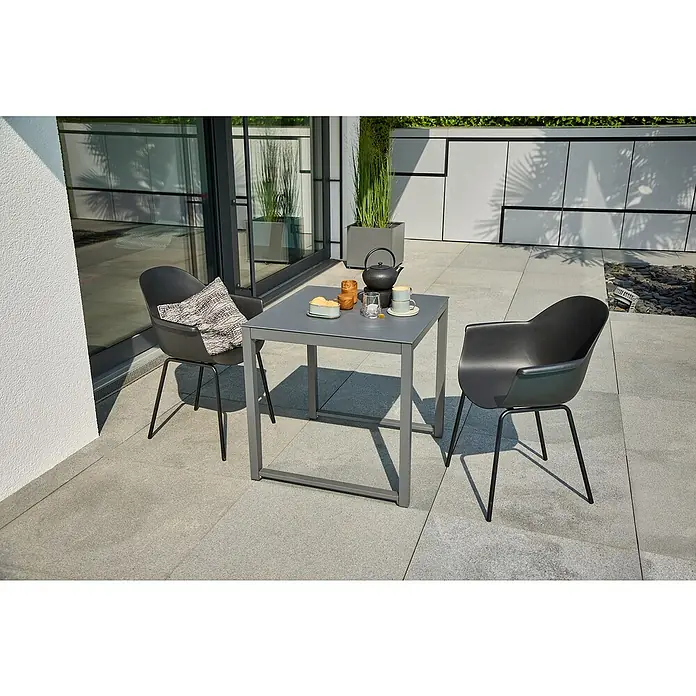 Sunfun Balkonmöbel-Set Amy/My - 3 -tlg., Night-Grey/Schwarz - Ein grauer Gartentisch mit zwei Stühlen auf einer Terrasse, gedeckt mit Geschirr und Snacks für ein entspanntes Beisammensein im Freien.