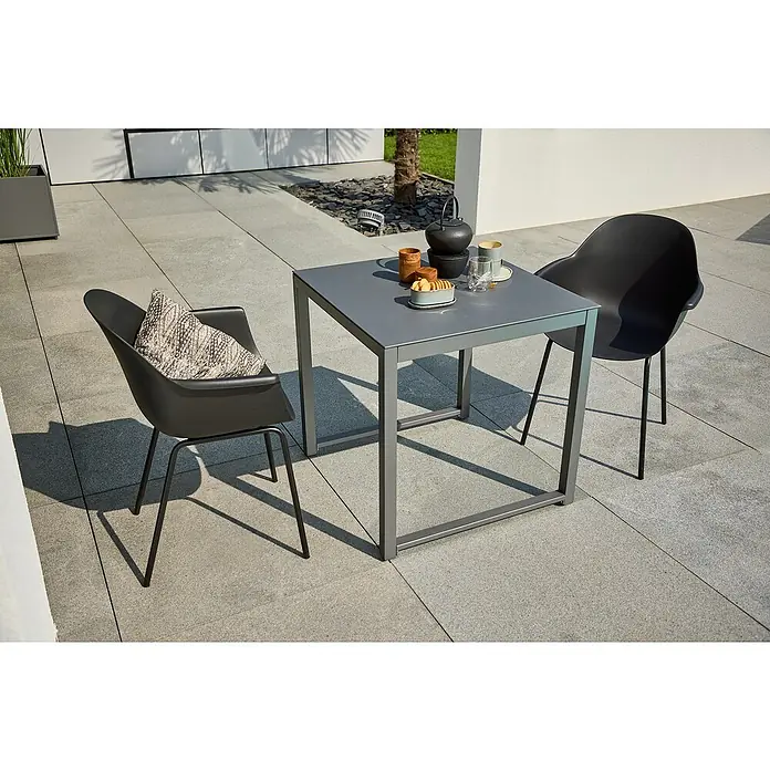Sunfun Amy Balkontisch - L x B x H: 74 x 74 x 74 cm, Aluminium, Glas, Quadratisch, Night-Grey - Ein grauer Gartentisch mit zwei Stühlen im Außenbereich, gedeckt mit Geschirr und Snacks für eine entspannte Atmosphäre im Freien.