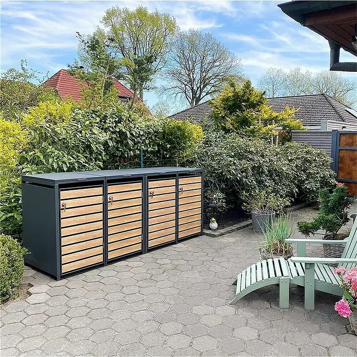 Metzler Mülltonnenbox - 272 x 80 cm, Stahl, Anthrazit/Braun, Geeignet für Anzahl Mülltonnen: 4 Stk. - Das Bild zeigt ein Mülltonnenbox-System mit Holzlattenfronten, das sich nahtlos in einen gepflegten Garten einfügt.