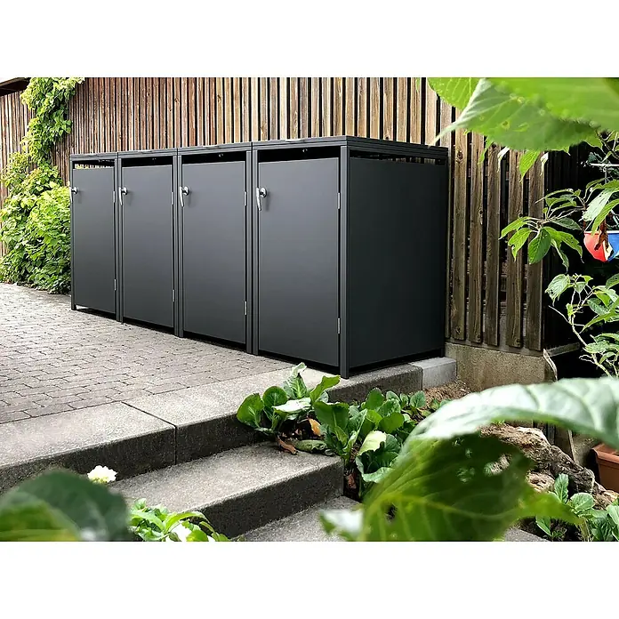 Metzler Mülltonnenbox 4er - 272 x 80 cm, Stahl, Anthrazit, Geeignet für Anzahl Mülltonnen: 4 Stk. - Ein Bild von vier grauen Mülltonnenboxen, die nebeneinander auf einer gepflasterten Fläche stehen und von Pflanzen umgeben sind.