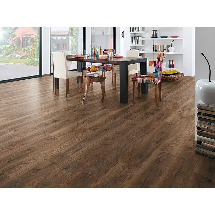 LOGOCLIC Aquaprotect Laminado Roble Renaissance - 1.288 x 195 x 12 mm, Roble Renaissance, AC5, Resistente al agua - Un comedor con una mesa de madera y sillas sobre un suelo laminado cálido y acogedor que muestra un aspecto de madera natural.