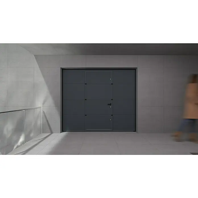 Solid Elements Puerta de garaje seccional PRO - 250 x 212,5 cm, Gris antracita, Peatonal - Primer plano de una puerta de garaje gris con diseño rectangular y puerta integrada, enclavada en una arquitectura de hormigón moderna.