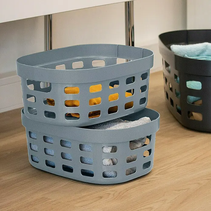 Sunware Sigma home Allzweck-Korb - L x B x H: 38 x 28 x 15,7 cm, Blau, Kunststoff - Gestapelte graue Wäschekörbe, gefüllt mit Wäsche, und ein schwarzer Wäschekorb im Hintergrund. Praktische Aufbewahrung für den Haushalt.