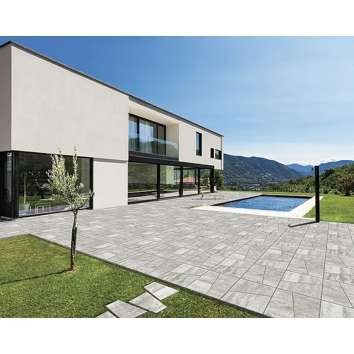 Terrassenplatte Division - 50 x 30 x 4 cm, Grau, Beton - Moderne Terrasse mit grauen Pflastersteinen, Pool und minimalistischem Haus im Hintergrund. Ideal für Außenbereiche mit Stil.
