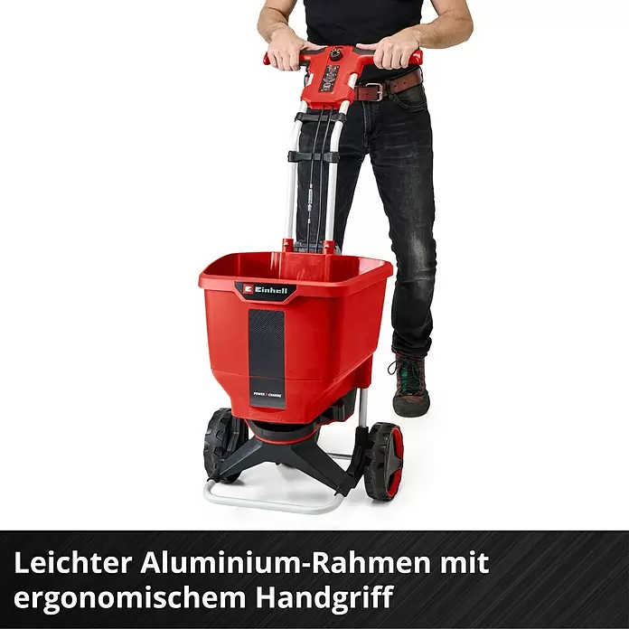 Einhell Power X-Change 18V Streuwagen GE-SR 18/22 - Akkubetrieben, Arbeitsbreite: 600 cm, 22 l - Roter und schwarzer Einhell Streuwagen mit leichtem Aluminiumrahmen und ergonomischem Griff, von einer Person bedient.