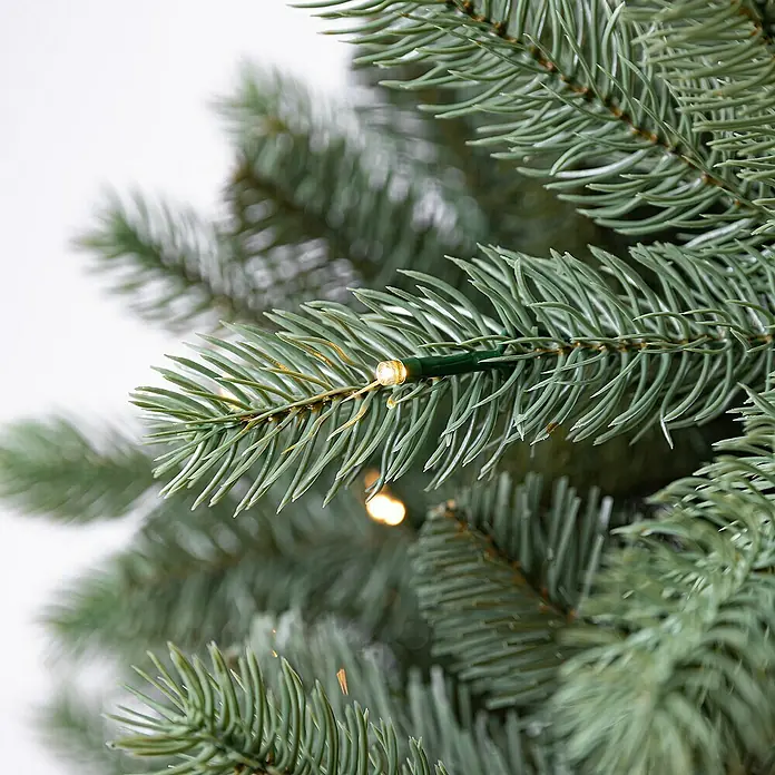Evergreen Künstlicher Weihnachtsbaum Vermont Fichte - Höhe: 210 cm, Grün, LED-Beleuchtung - Nahaufnahme eines geschmückten künstlichen Weihnachtsbaums mit warmweißen Lichtern, die eine festliche Atmosphäre schaffen.