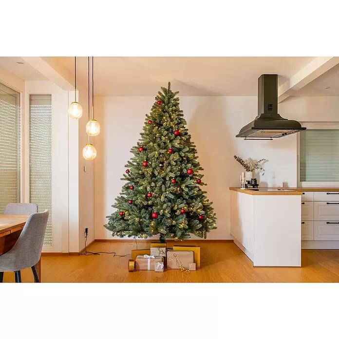 Evergreen Künstlicher Weihnachtsbaum Vermont Fichte - Höhe: 240 cm, Grün, LED-Beleuchtung - Großer künstlicher Weihnachtsbaum, geschmückt mit roten Kugeln und warmen Lichtern, mit Geschenken darunter in einem modernen Interieur.