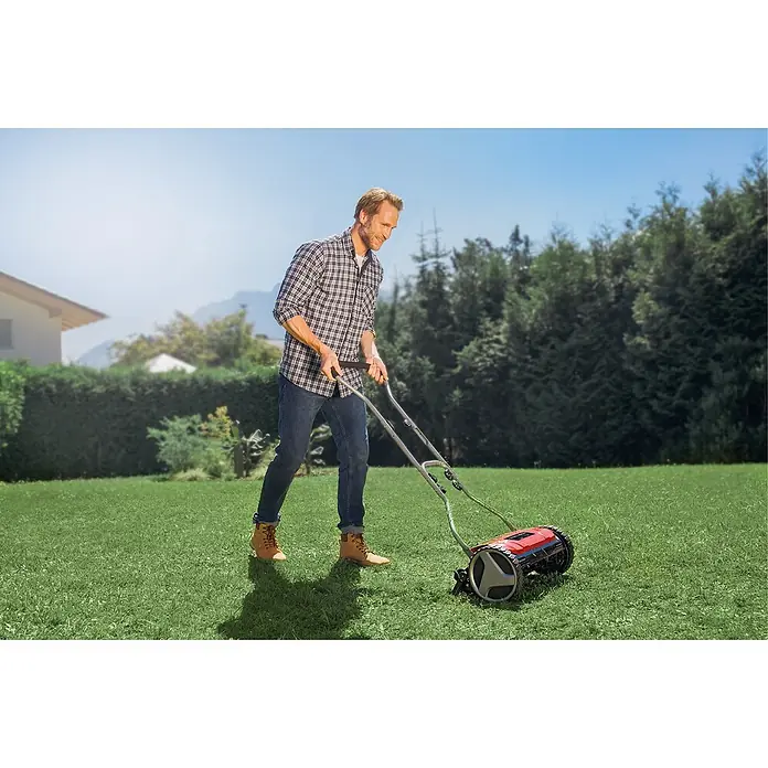 Einhell Spindelmäher GE-HM 38 S - Schnittbreite: 38 cm - Ein Mann mäht den Rasen mit einem roten Spindelmäher. Der Rasenmäher ist das Hauptprodukt im Bild.