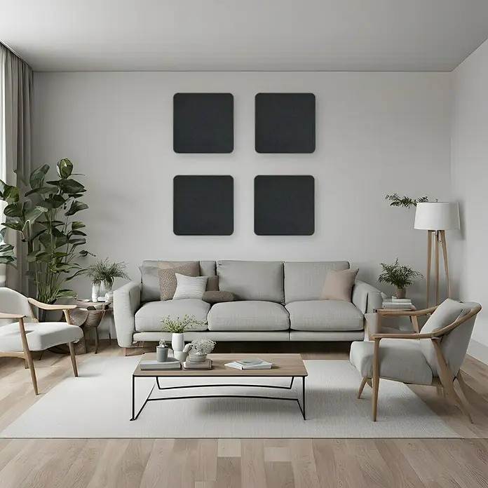 Silenti Akustikpaneel - 4 Stk., Anthrazit, 50 cm x 50 cm x 50 mm - Ein helles Wohnzimmer mit einem grauen Sofa, Sesseln, einem Couchtisch und vier quadratischen, dunklen Wandpaneelen.