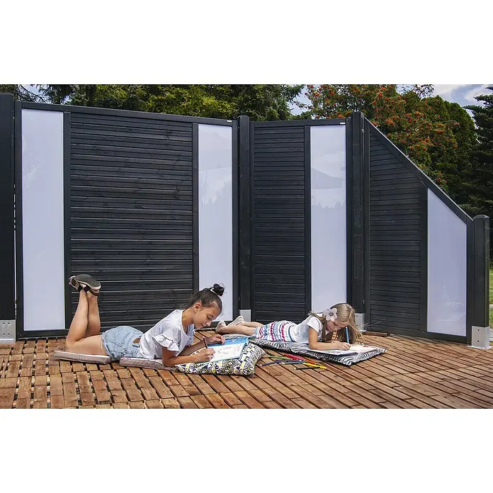 Andrewex Sichtschutzelement Duo - 180 x 180 cm, Anthrazit - Zwei Mädchen liegen auf einer Holzterrasse und zeichnen vor einem modernen Sichtschutzzaun mit weißen Elementen. Die Kinder genießen ihre Freizeit im Freien.