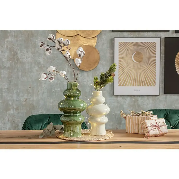 Reinders Bild Slim Frame Black - Moon, B x H: 40 x 50 cm - Dekorative Szene mit einer grünen und einer weißen Vase auf einem Tisch, umgeben von Weihnachtsgeschenken und festlicher Beleuchtung.