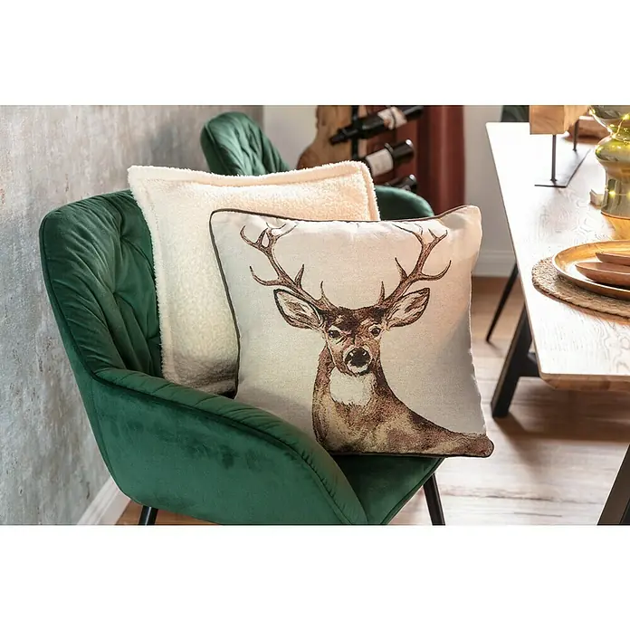 Kissen Hirsch - Braun, 45 x 45 cm, 100 % Polyester - Dekorative Kissen auf einem grünen Samtstuhl: Ein cremefarbenes Fellkissen und ein Kissen mit einem Hirschmotiv sorgen für eine gemütliche Atmosphäre.