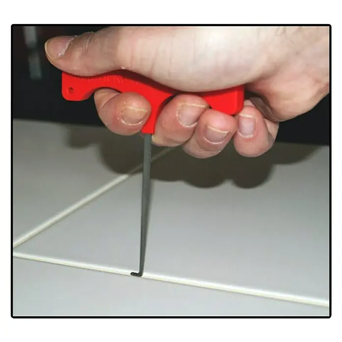 Heka Plattenheber - Plattenstärke: 0 mm - 70 mm - Nahaufnahme eines Handwerkers, der eine rote Fugenreinigungswerkzeug zum Entfernen von Fugenmörtel zwischen Fliesen benutzt.