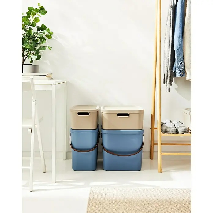Rotho Aufbewahrungsbox - L x B x H: 39,2 x 35,5 x 17,7 cm, Kunststoff, Cappuccino, 20 l - Zwei blaue Mülleimer mit beigen Deckeln, gestapelt in einem hellen Raum. Praktische Aufbewahrungslösung für ein stilvolles Zuhause.