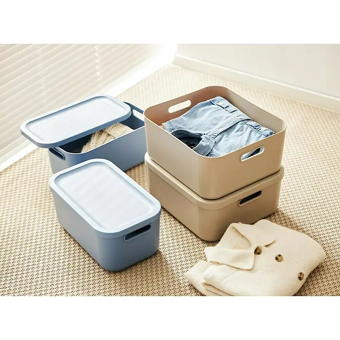 Rotho Aufbewahrungsbox - L x B x H: 39,2 x 35,5 x 17,7 cm, Kunststoff, Cappuccino, 20 l - Drei Aufbewahrungsboxen in Blau und Beige mit Kleidung auf einem Teppich, ideal zur stilvollen Aufbewahrung von Kleidung und Accessoires.