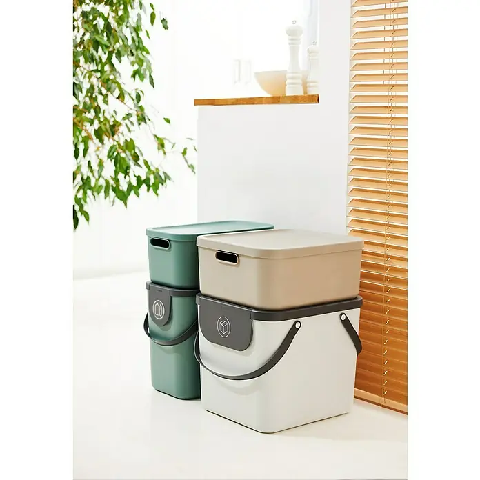 Rotho Aufbewahrungsbox - L x B x H: 39,2 x 23,5 x 17,7 cm, Kunststoff, Mistelzweiggrün, 12 l - Zwei Recycling-Behälter in Grün und Beige/Weiß stehen gestapelt auf einem hellen Boden. Ideal für die Mülltrennung in Küche oder Büro.